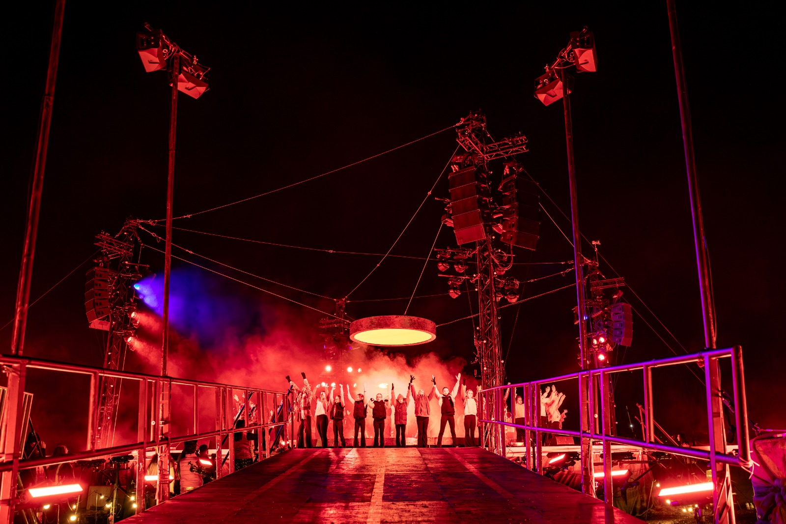 Brighter Still BD25 closing ceremony — performers on circular stage platform in outdoor field, Bradford 2025